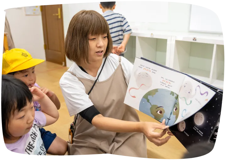 絵本を読み聞かせる先生と子どもたち