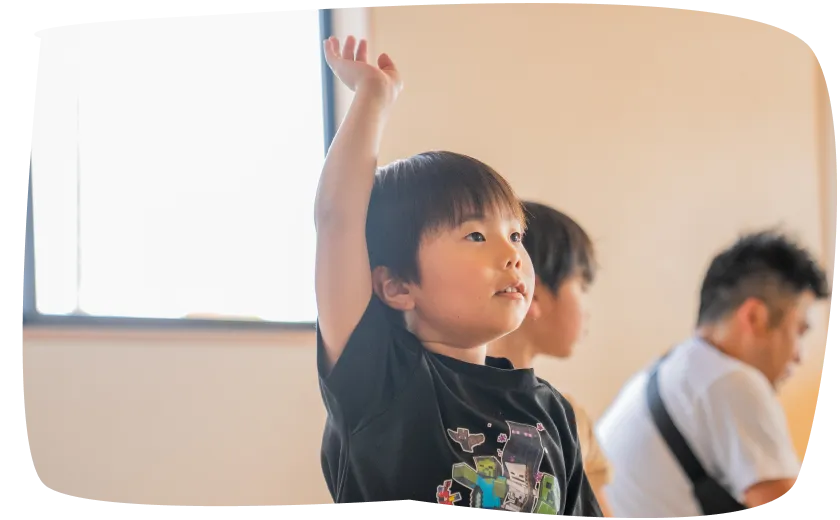 ホワイトボードの前で学ぶ子どもとスタッフ